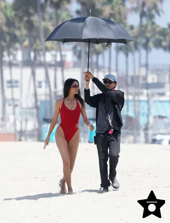 shay-mitchell-films-baywatch-in-a-red-swimsuit-july-2026-1 Shay Mitchell Films Baywatch in a Red Swimsuit July 2026