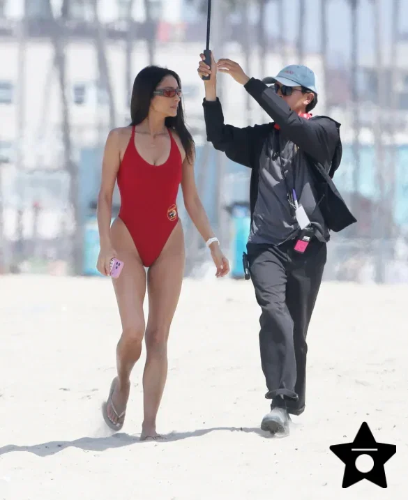 shay-mitchell-films-baywatch-in-a-red-swimsuit-july-2026-3 Shay Mitchell Films Baywatch in a Red Swimsuit July 2026