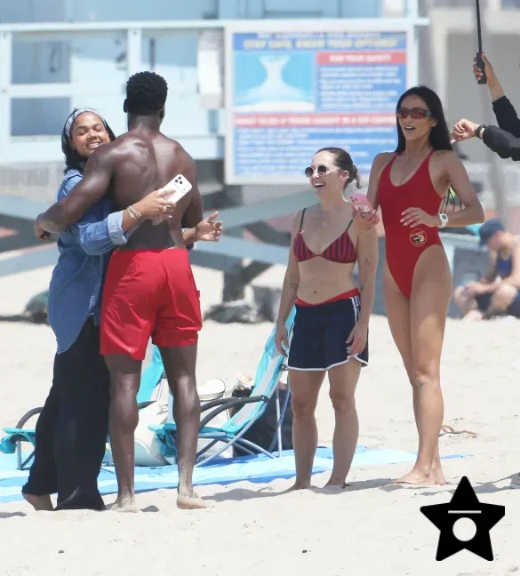 shay-mitchell-films-baywatch-in-a-red-swimsuit-july-2026-6 Shay Mitchell Films Baywatch in a Red Swimsuit July 2026